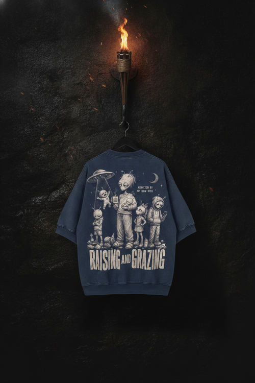 Abducted — navy acid-wash tee on a forged-iron torch in the cavern